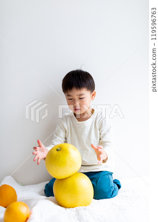 Boy holding fruits: grapefruit, pomelo 119596763