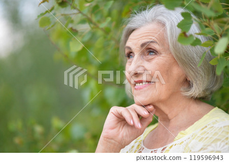 Portrait of a beautiful elderly woman in the park Portrait of a beautiful elderly woman in the park 119596943
