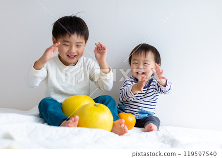 Brothers holding fruits: grapefruit, pomelo 119597540