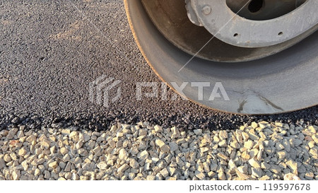 Asphalt paving roller. Road roller laying fresh asphalt, working on the new road construction site Asphalt paving roller. Road roller laying fresh asphalt, working on the new road construction site 119597678