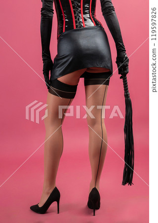 Beauty lady in a black latex dress holding the whip 119597826