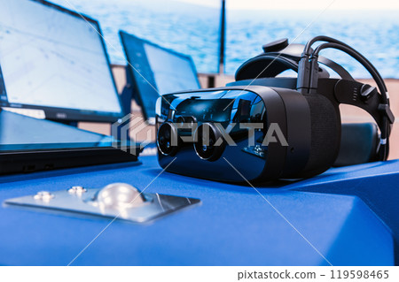 Ship control panel with VR headset laying on it, marine navigation 119598465