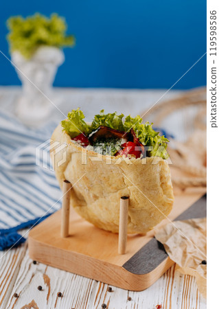 Fresh pita stuffed with vegetables, herbs, and sauce, perfect for a healthy and quick meal option Fresh pita stuffed with vegetables, herbs, and sauce, perfect for a healthy and quick meal option 119598586