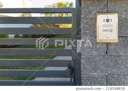 Metal Gate with Intercom on Stone Wall 119598650
