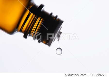 A drop of antihistamine or essential oil drips from a bottle. Close-up. A drop of antihistamine or essential oil drips from a bottle. Close-up. 119599278