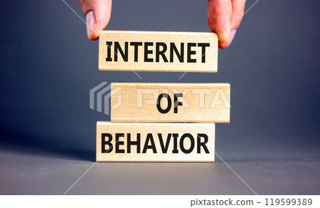 Internet of behavior symbol. Concept words Internet of behavior on wooden block on a beautiful grey table grey background. Businessman hand. Business Internet of behavior concept. Copy space. 119599389