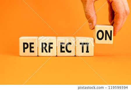 Perfection symbol. Concept word Perfection on beautiful wooden blocks. Beautiful orange background. Businessman hand. Business perfection concept. Copy space. Perfection symbol. Concept word Perfection on beautiful wooden blocks. Beautiful orange background. Businessman hand. Business perfection concept. Copy space. 119599394