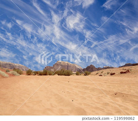 Wadi Rum Desert also known as The Valley of the Moon (against the sky with clouds)-- is a valley cut into the sandstone and granite rock in southern Jordan 60 km to the east of Aqaba 119599862