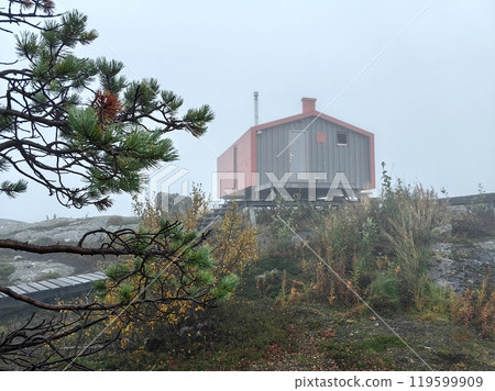 Foggy morning at Volosyanaya Mountain, Kandalaksha, showcasing a cozy Dubldom shelter surrounded by nature's beauty 119599909