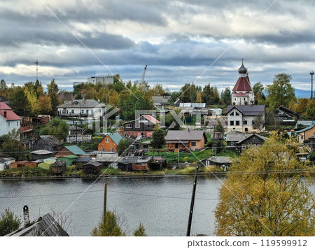 A picturesque view of Kandalaksha on the Kola Peninsula with colorful houses and serene waters reflecting the autumn sky 119599912