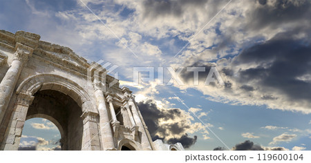 Arch of Hadrian in Gerasa (Jerash)-- was built to honor the visit of emperor Hadrian to Jerash in 129/130 AD, Jordan. Against the background of a beautiful sky with clouds Arch of Hadrian in Gerasa (Jerash)-- was built to honor the visit of emperor Hadrian to Jerash in 129/130 AD, Jordan. Against the background of a beautiful sky with clouds 119600104