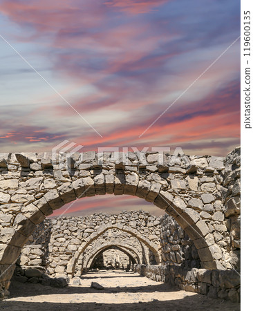Ruins of Azraq Castle (Qasr al-Azraq) is a crusader castle (300AD),  central-eastern Jordan, 100 km east of Amman, Jordan. Against the background of a beautiful sky with clouds 119600135
