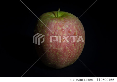 One fresh ripe apple fruit in minimalist style on dark background. One fresh ripe apple fruit in minimalist style on dark background. 119600466
