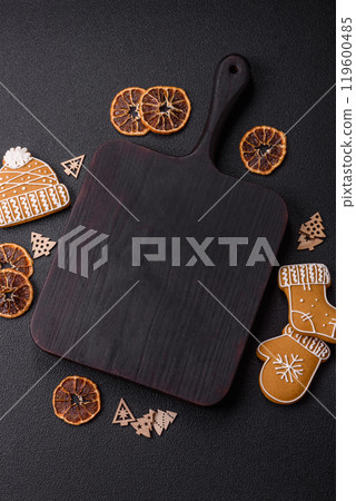 Empty wooden cutting board with copy space with gingerbread cookies and Christmas decor 119600485