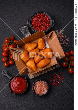 Breaded camembert or brie cheese baked in the form of nuggets with salt and spices Breaded camembert or brie cheese baked in the form of nuggets with salt and spices 119600671