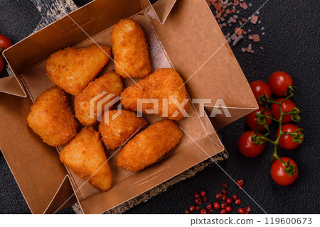 Breaded camembert or brie cheese baked in the form of nuggets with salt and spices Breaded camembert or brie cheese baked in the form of nuggets with salt and spices 119600673