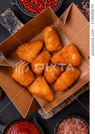 Breaded camembert or brie cheese baked in the form of nuggets with salt and spices Breaded camembert or brie cheese baked in the form of nuggets with salt and spices 119600674