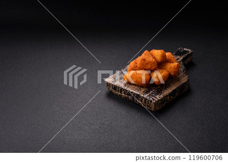 Breaded camembert or brie cheese baked in the form of nuggets with salt and spices Breaded camembert or brie cheese baked in the form of nuggets with salt and spices 119600706