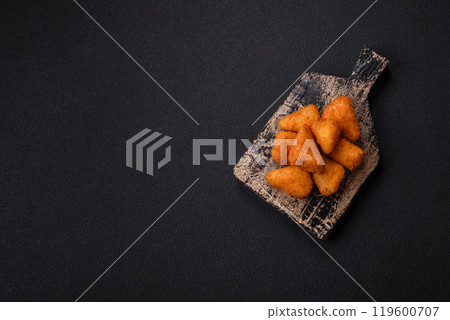 Breaded camembert or brie cheese baked in the form of nuggets with salt and spices Breaded camembert or brie cheese baked in the form of nuggets with salt and spices 119600707