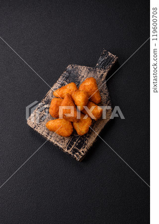 Breaded camembert or brie cheese baked in the form of nuggets with salt and spices Breaded camembert or brie cheese baked in the form of nuggets with salt and spices 119600708