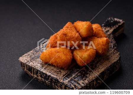 Breaded camembert or brie cheese baked in the form of nuggets with salt and spices Breaded camembert or brie cheese baked in the form of nuggets with salt and spices 119600709