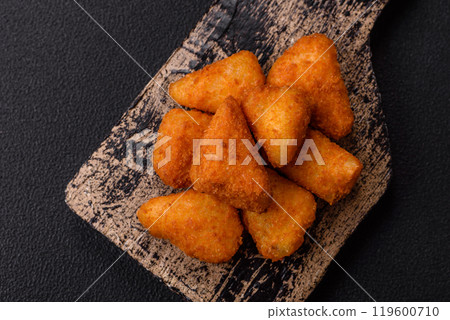Breaded camembert or brie cheese baked in the form of nuggets with salt and spices Breaded camembert or brie cheese baked in the form of nuggets with salt and spices 119600710