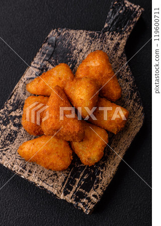 Breaded camembert or brie cheese baked in the form of nuggets with salt and spices Breaded camembert or brie cheese baked in the form of nuggets with salt and spices 119600711