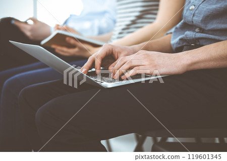 Group of casual dressed business people working at meeting or conference, close-up of hands. Businessman using laptop computer. Teamwork or coaching concept Group of casual dressed business people working at meeting or conference, close-up of hands. Businessman using laptop computer. Teamwork or coaching concept 119601345