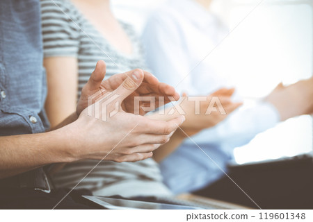 Business people clapping at meeting or conference, close-up of hands. Group of unknown businessmen and women in sunny office Business people clapping at meeting or conference, close-up of hands. Group of unknown businessmen and women in sunny office 119601348