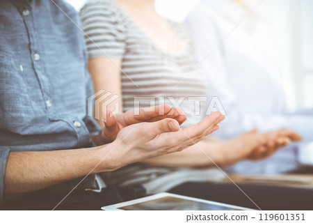 Business people clapping at meeting or conference, close-up of hands. Group of unknown businessmen and women in sunny office 119601351