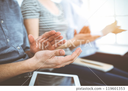 Business people clapping at meeting or conference, close-up of hands. Group of unknown businessmen and women in sunny office 119601353