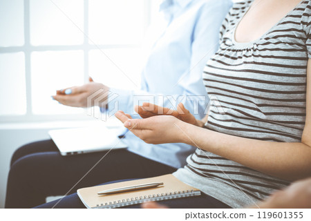 Business people clapping at meeting or conference, close-up of hands. Group of unknown businessmen and women in modern white office. Success teamwork, corporate coaching and applause concept Business people clapping at meeting or conference, close-up of hands. Group of unknown businessmen and women in modern white office. Success teamwork, corporate coaching and applause concept 119601355
