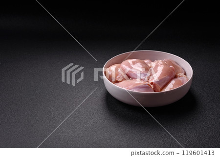 Fresh chicken fillet on a dark concrete table with spices and herbs Fresh chicken fillet on a dark concrete table with spices and herbs 119601413