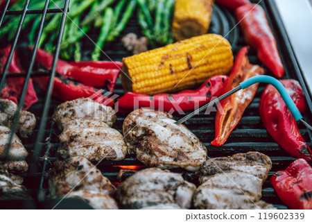 Grilled chicken meat with vegetables on barbecue grill with smoke. Grilled chicken meat with vegetables on barbecue grill with smoke. 119602339