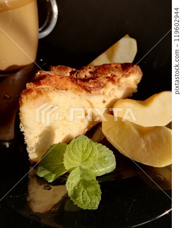 Сup of coffee tea on the table with a homemade cake decorated with a fresh mint Сup of coffee tea on the table with a homemade cake decorated with a fresh mint 119602944