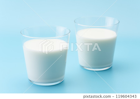 Milk in a glass on a light blue background 119604343