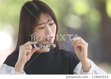 Woman with broken glasses 119605014