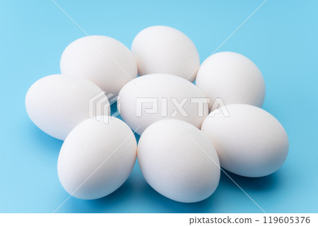 Multiple eggs on a light blue background Multiple eggs on a light blue background 119605376