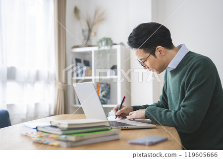 A man in his late 30s working at a desk, profile A man in his late 30s working at a desk, profile 119605666
