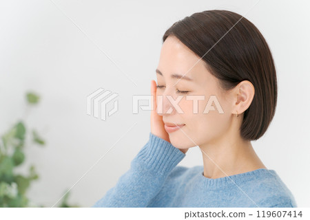 Woman doing skincare with a smile Woman doing skincare with a smile 119607414