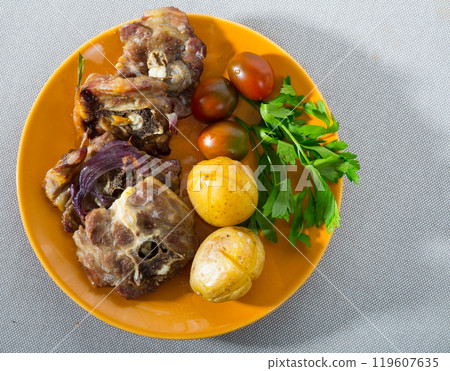 Top view of baked lamb leg chops with potatoes, tomatoes, greens Top view of baked lamb leg chops with potatoes, tomatoes, greens 119607635