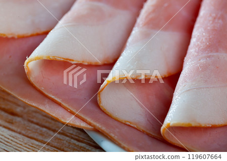 Sliced appetizing ham closeup wooden board Sliced appetizing ham closeup wooden board 119607664
