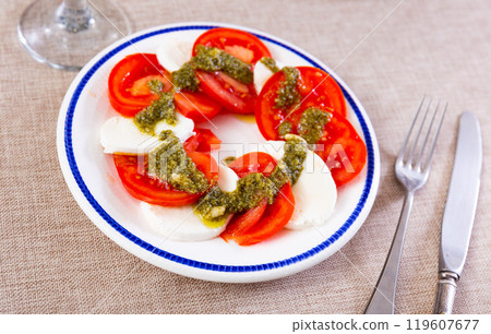 Traditional appetizer of Italian cuisine is Caprese with pesto sauce 119607677