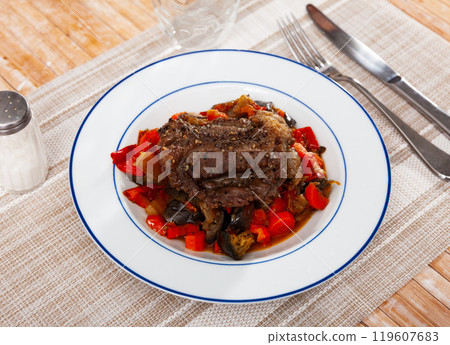 Baked pork with side dish of sauteed veggies on plate Baked pork with side dish of sauteed veggies on plate 119607683