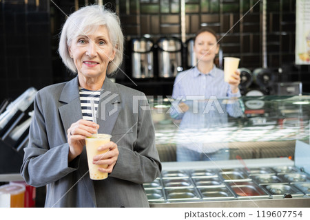 Senior woman drinks tonic bubble tea through straw Senior woman drinks tonic bubble tea through straw 119607754