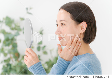 Woman doing skincare with a smile Woman doing skincare with a smile 119607781
