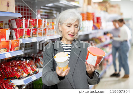 Senior woman in supermarket buys instant fast food in bowl 119607804