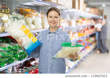 Positive woman choosing noodles for dinner in Asian food store 119607831