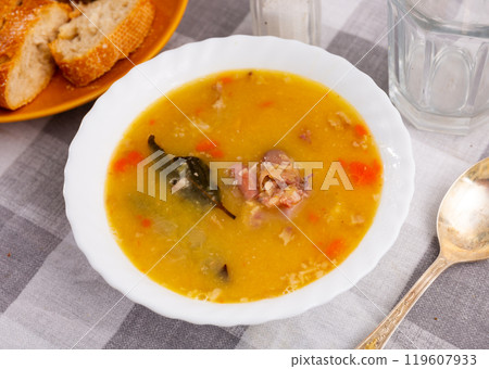 Hot pea soup with smoked meats and vegetables 119607933