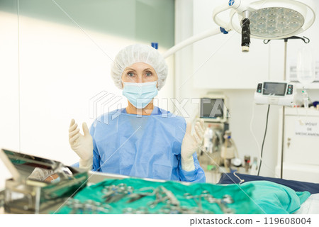 Aged female veterinarian ready to conduct surgical operation at veterinary clinic Aged female veterinarian ready to conduct surgical operation at veterinary clinic 119608004